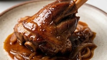 Stinco d’agnello confit agli scalogni caramellati
